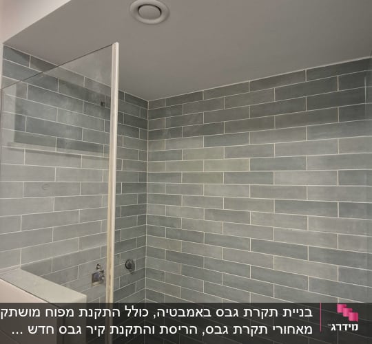 חדר מקלחת עם אריחים אפורים על הקירות